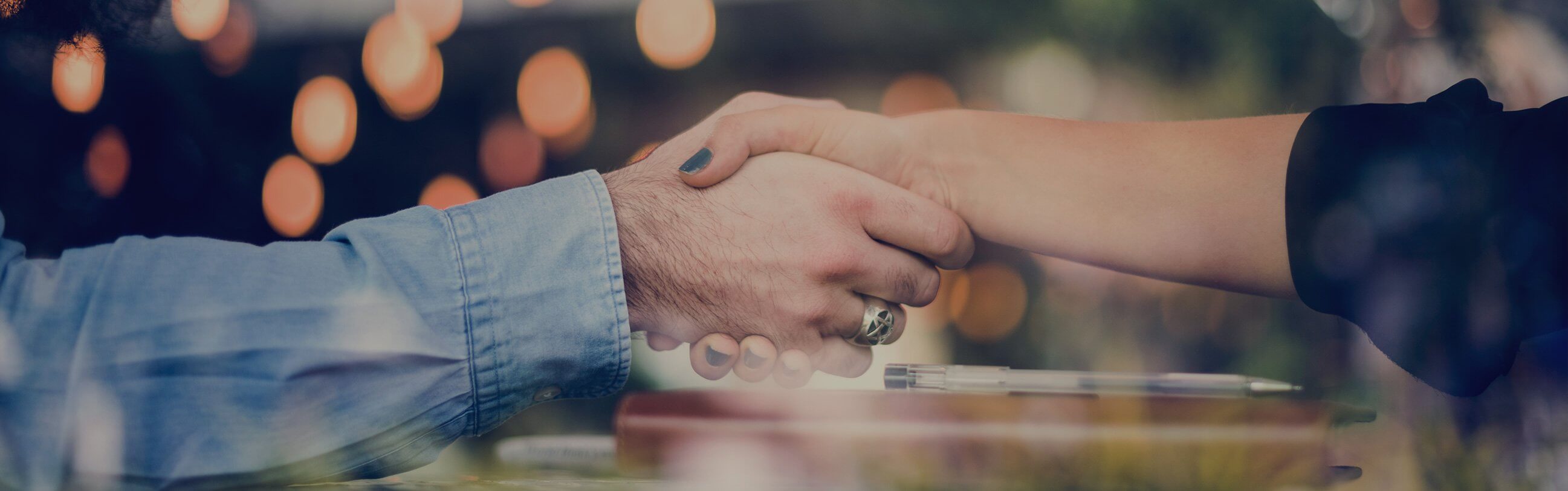 A man and a woman's hands shaking to illustrate Amazon's Find-a-Partner Directory.